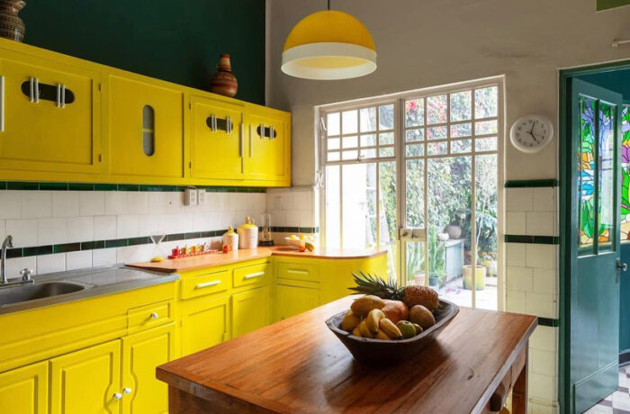 A wooden dining table with a bowl full of fruits
