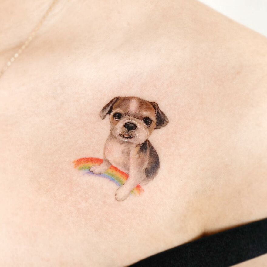 Tattoo featuring a painting-like puppy with a rainbow, blending elements of nature and animals.