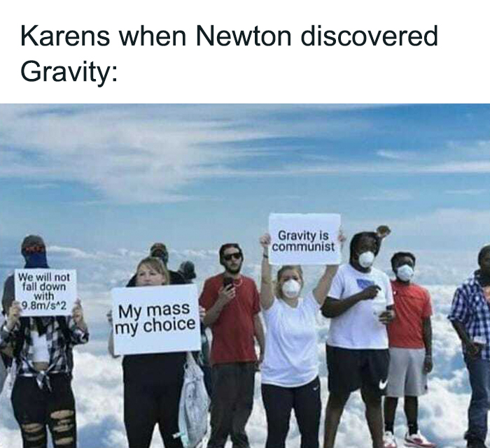 People holding humorous signs about gravity, including "My mass my choice" and "Gravity is communist," to depict physics jokes.