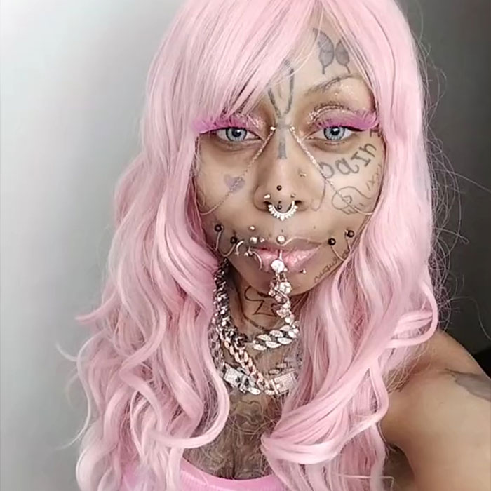 Inked grandmother, 41, with pink hair and facial tattoos, expressing confidence despite criticism.