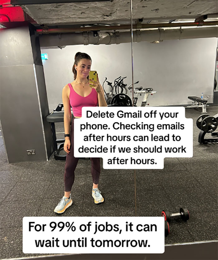 Woman in gym mirror selfie, wearing a pink top, shares burnout advice about being boring and email management.