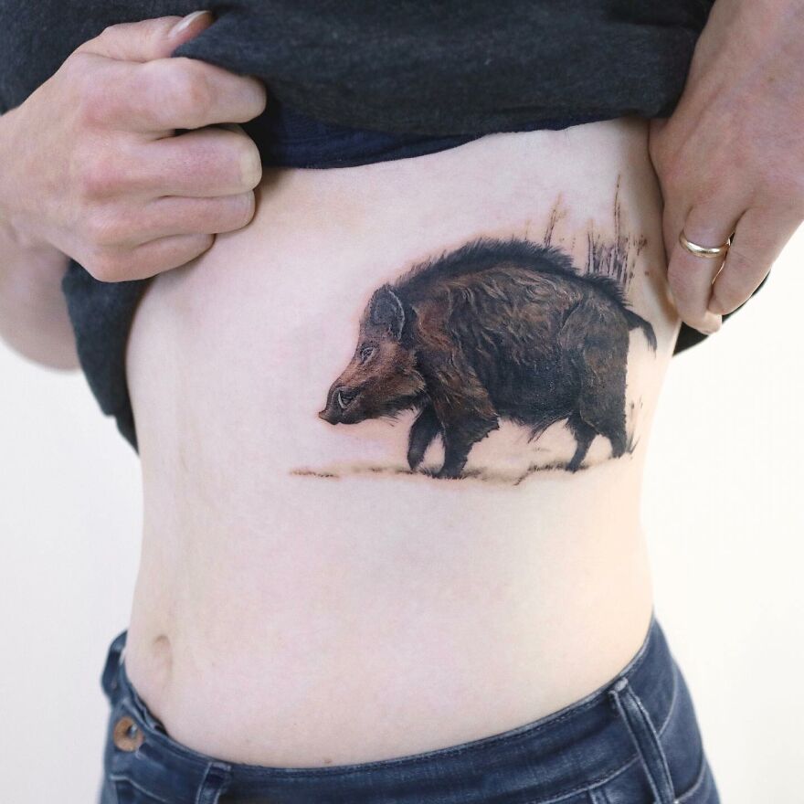 Tattoo of a wild boar, blending nature and art on a person's side, by Korean ink artist.