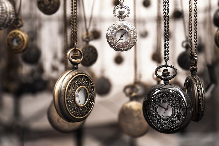 Vintage pocket watches with intricate designs hanging on chains, one weird surprise people found after moving into a new home.