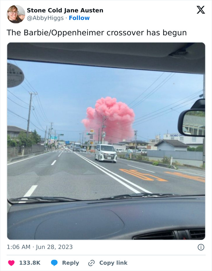 Funny 2023 meme with a pink cloud resembling an explosion, seen from a car windshield on a street.