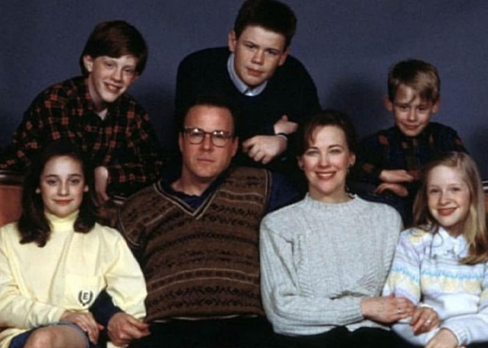 "Home Alone cast featuring Catherine O'Hara, seated with co-stars in a family pose.