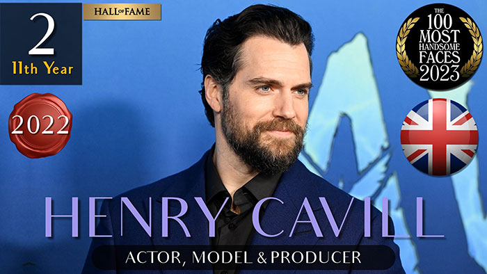 Man in a suit, recognized among the most handsome men of 2023 by The Independent Critics, with award badges displayed.