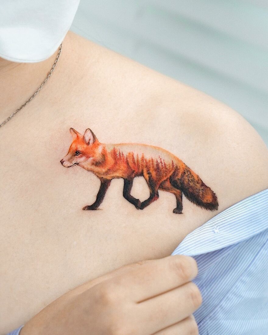 Tattoo of a fox with nature elements on shoulder, showcasing painting-like style by Korean ink artist.
