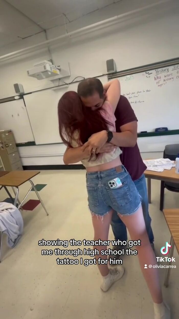 Student hugging teacher after getting meaningful handwritten tattoo.