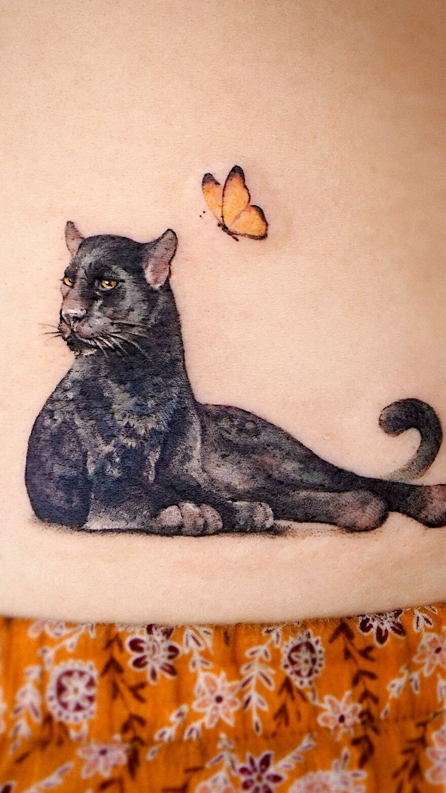 Tattoo of a panther with a butterfly, showcasing elements of nature and animals by a Korean ink artist.