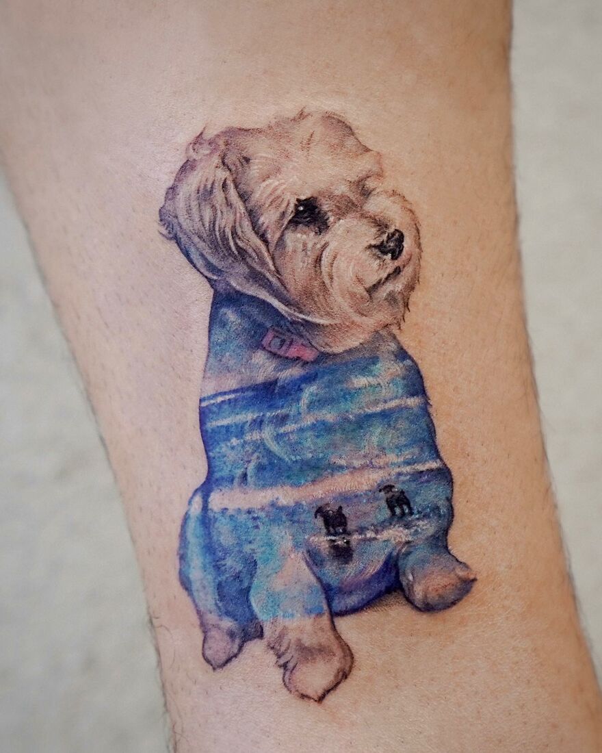 Tattoo of a fluffy dog in a painting-like style, incorporating nature elements with waves and figures on the fur.