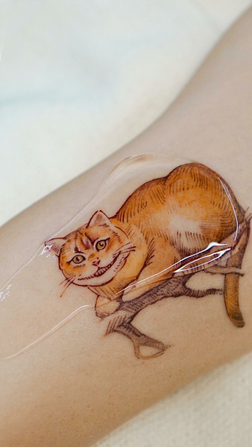 Tattoo of a painting-like cat on a branch, showcasing nature and animal elements by a Korean ink artist.