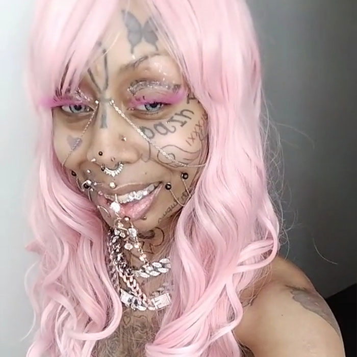 Inked grandmother, 41, with pink hair and tattoos, proudly showcases her unique look despite criticism.