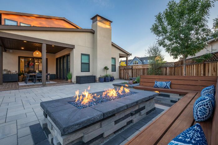 Outdoor backyard with banquette seating and a modern fireplace, showcasing chic backyard ideas for stylish outdoor living.