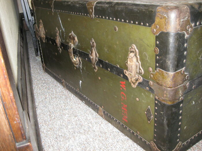 Old green metal trunk with rusted corners found as a weird surprise after moving into a new home.