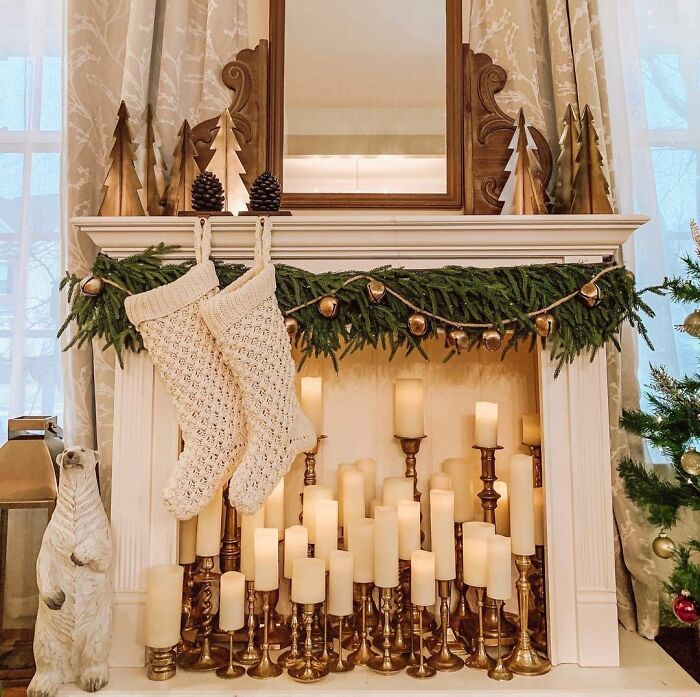 Cozy Christmas decor with candles of various sizes on a fireplace, showcasing affordable holiday decoration ideas.