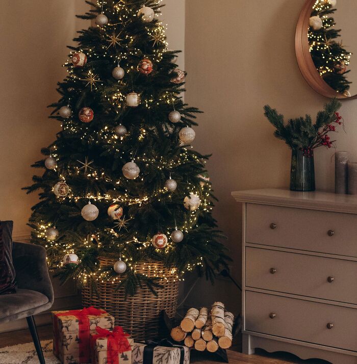 Decorated Christmas tree with affordable Christmas decor ideas, featuring warm lights and simple ornaments in a cozy living room.