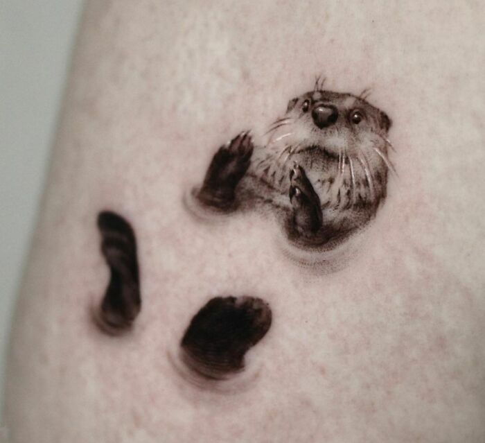 3D tattoo of a realistic otter, with its head and paws appearing to emerge from the skin, showcasing breathtaking detail.