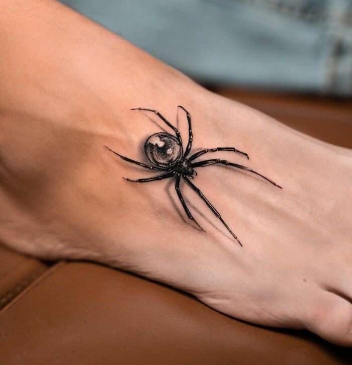Intricate 3D spider tattoo on a foot, showcasing advanced tattoo artistry.