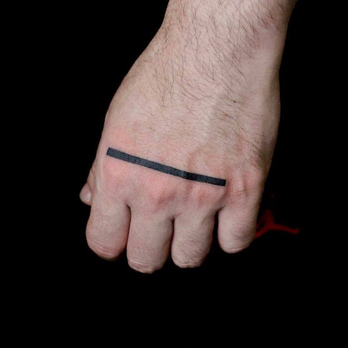 Minimalist black line tattoo on a hand, showcasing small hand tattoo design.