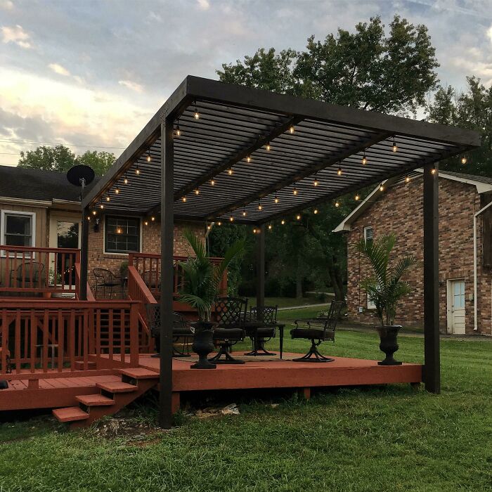 Modern pergola in a backyard featuring string lights and outdoor seating, perfect for chic outdoors and budget-friendly backyard ideas.