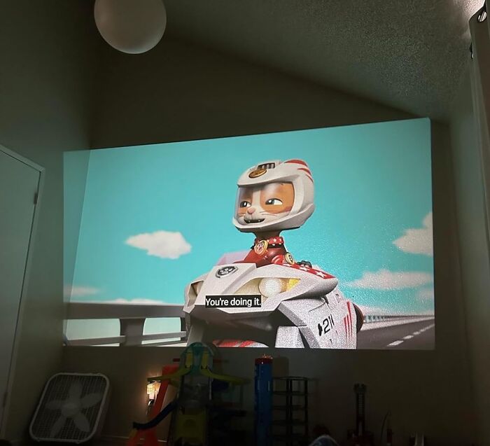 Animated character riding a motorcycle, projected on a wall, suitable as a last-minute Christmas gift idea with Amazon Prime.