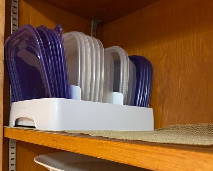 Tray organizer with plastic lids in a cabinet for decluttering and organizing your home.