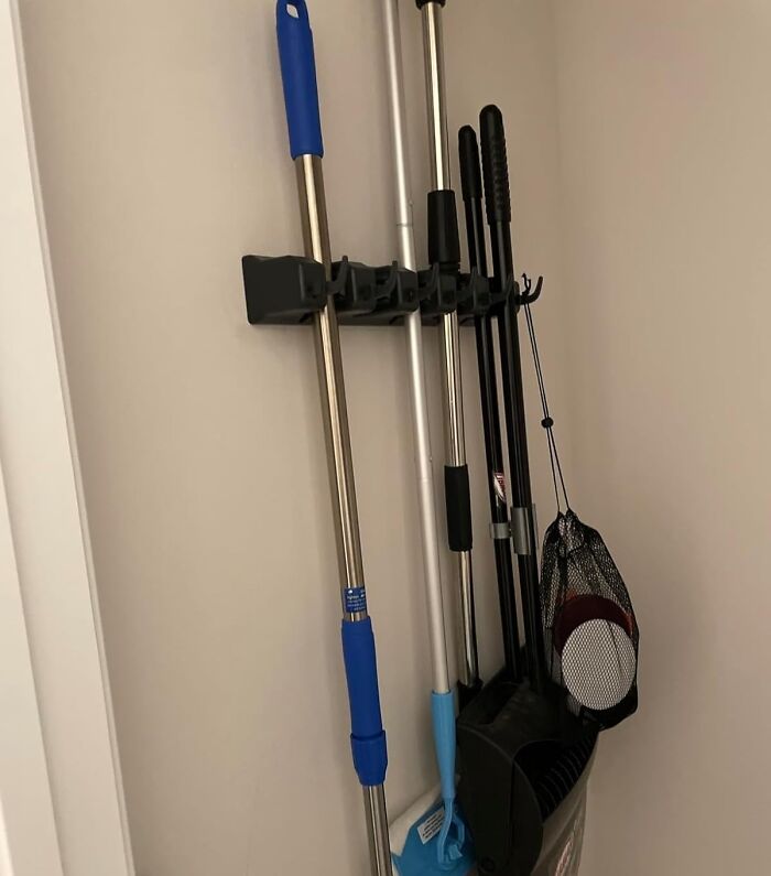 Wall-mounted rack with brooms and cleaning tools for home organization 2024.