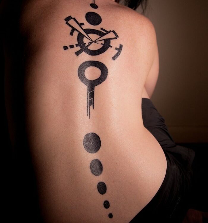 Geometric black spine tattoo with circular patterns on a person's back.
