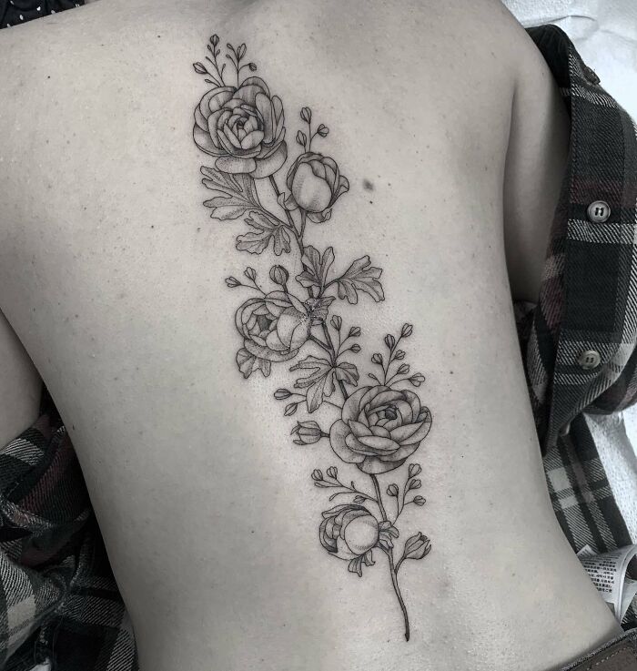 Floral spine tattoo showcasing intricate details along the back.