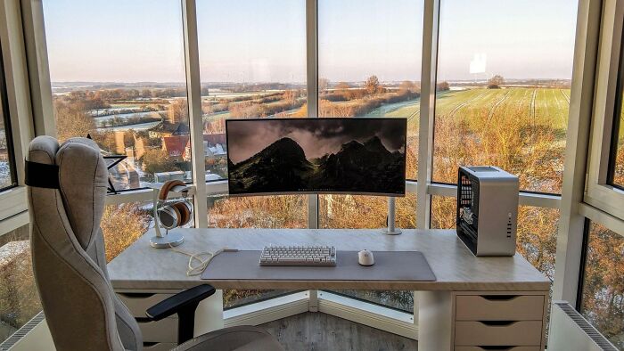 Minimalist home office design with curved monitor, ergonomic chair, and scenic window views showcasing cozy workspace ideas.