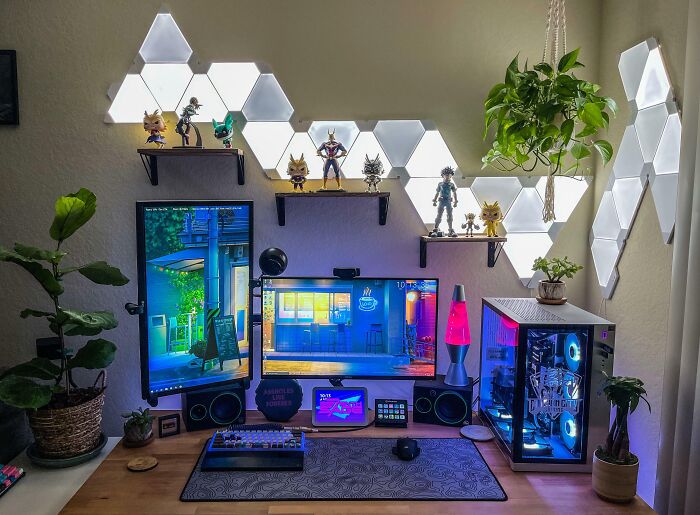 Cozy home office design with dual monitors, LED wall lights, plants, collectibles, and a modern PC setup on a wooden desk.