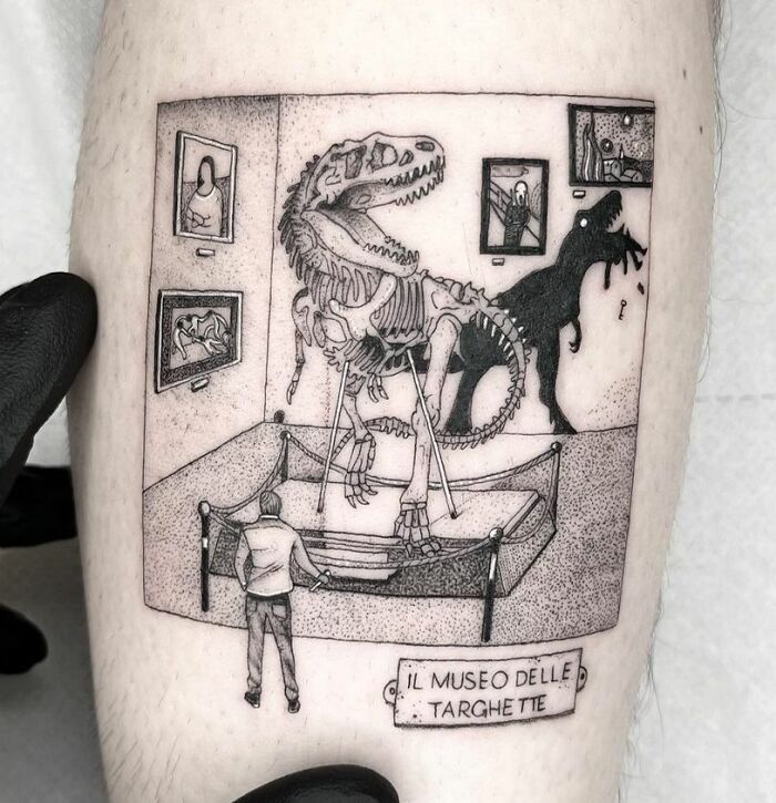 A detailed dinosaur tattoo featuring a museum scene with a skeleton and shadow on display.