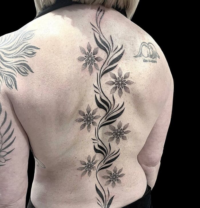 Floral spine tattoo with intricate designs stretching down the back.
