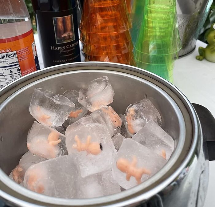 Ice cubes with tiny plastic figures inside, surrounded by colorful cups; a funny product idea for 2024.