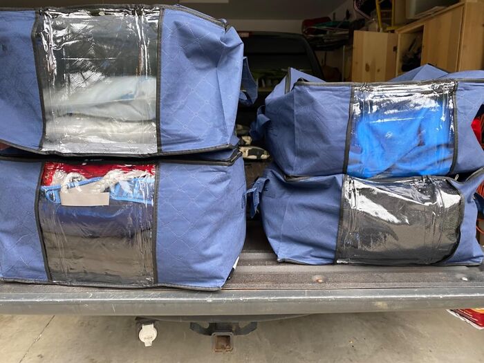 Blue storage bags on a truck bed for home decluttering and organization in 2024.