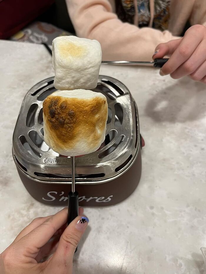 Toasting marshmallows in a mini s'mores maker, a perfect Christmas gift idea.