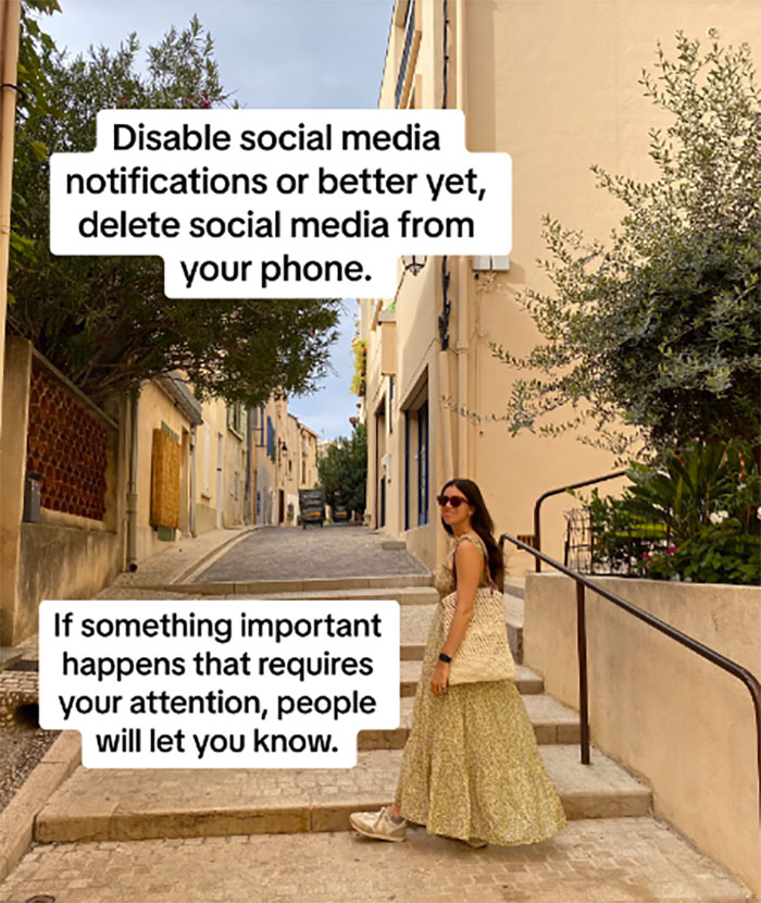Woman in a summer dress walks on a quiet street, suggesting to disable social media for burnout relief advice.