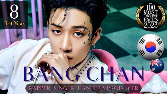 Rapper and producer with tattoos, ranked among the most handsome men of 2023, sitting on a pink chair.