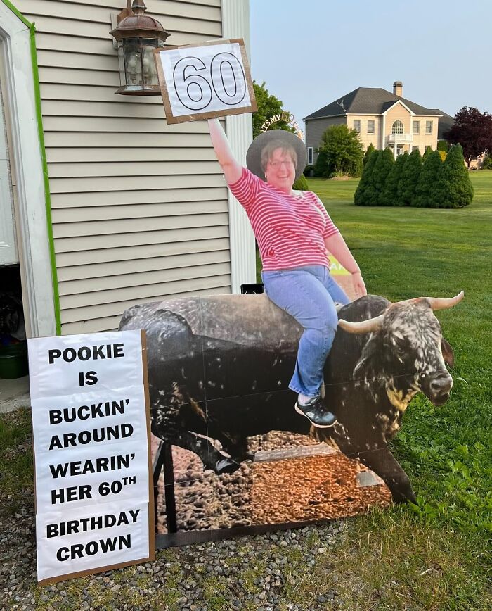 Cardboard cutout of a person on a bull, holding up a "60" sign for a funny 60th birthday celebration.