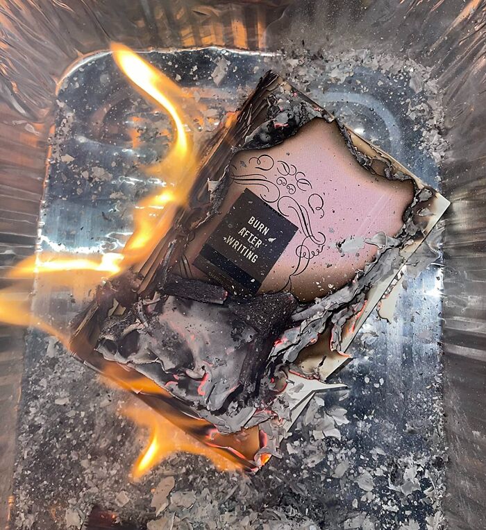 Burning paper in a metal tray symbolizing motivation and the start of pursuing goals for 2025 success.