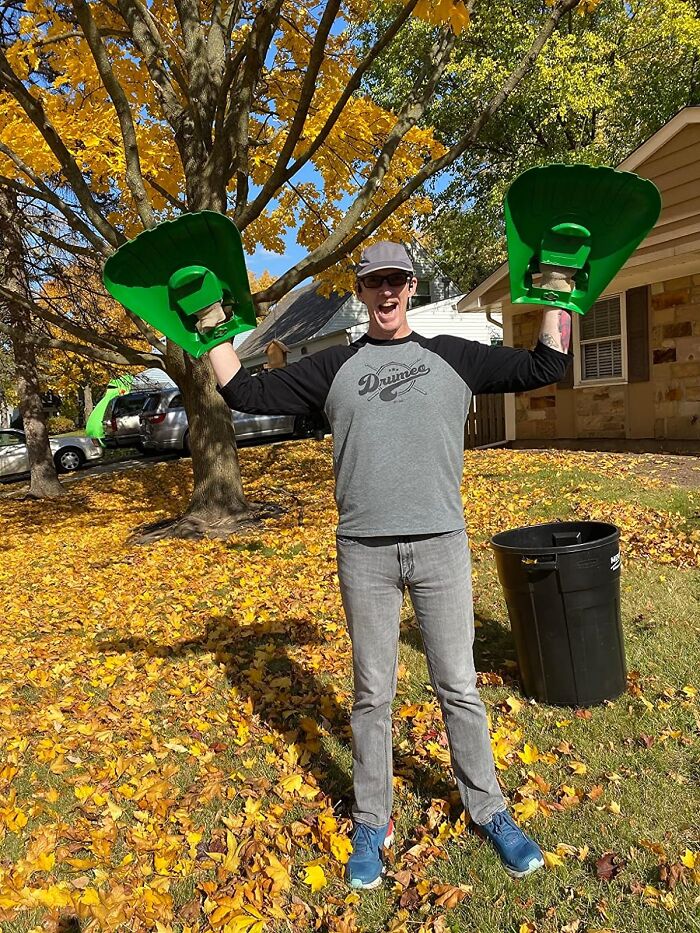Person wearing giant green leaf grabbers, smiling in autumn yard, a unique gift for the father who has everything.