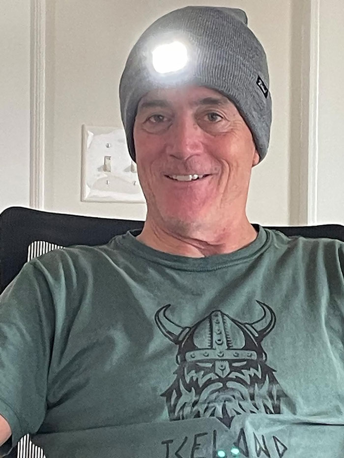 Man smiling indoors wearing a gray beanie with light and a green Iceland shirt for Father's Day gift ideas.