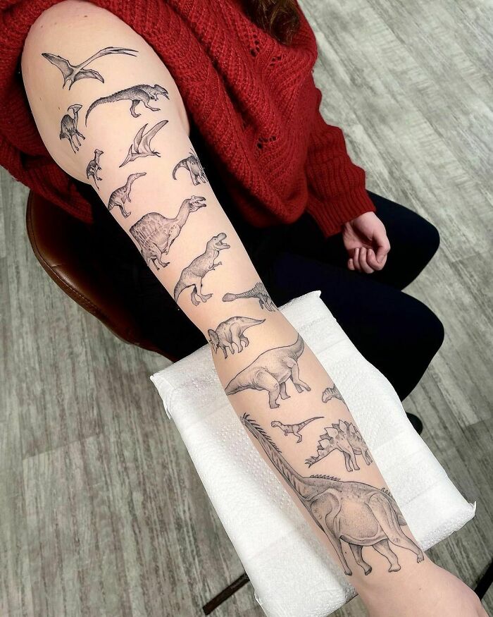 Arm with a detailed dinosaur tattoo design featuring various species, executed perfectly.