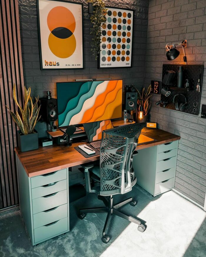 Modern home office design with ergonomic chair, dual monitor setup, wooden desk, and cozy decor elements.