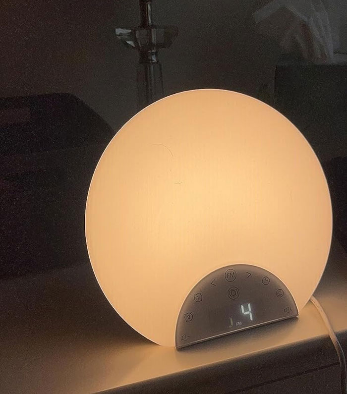 Round wake-up light on a nightstand glowing softly, symbolizing a fresh start to pursuing goals and success.