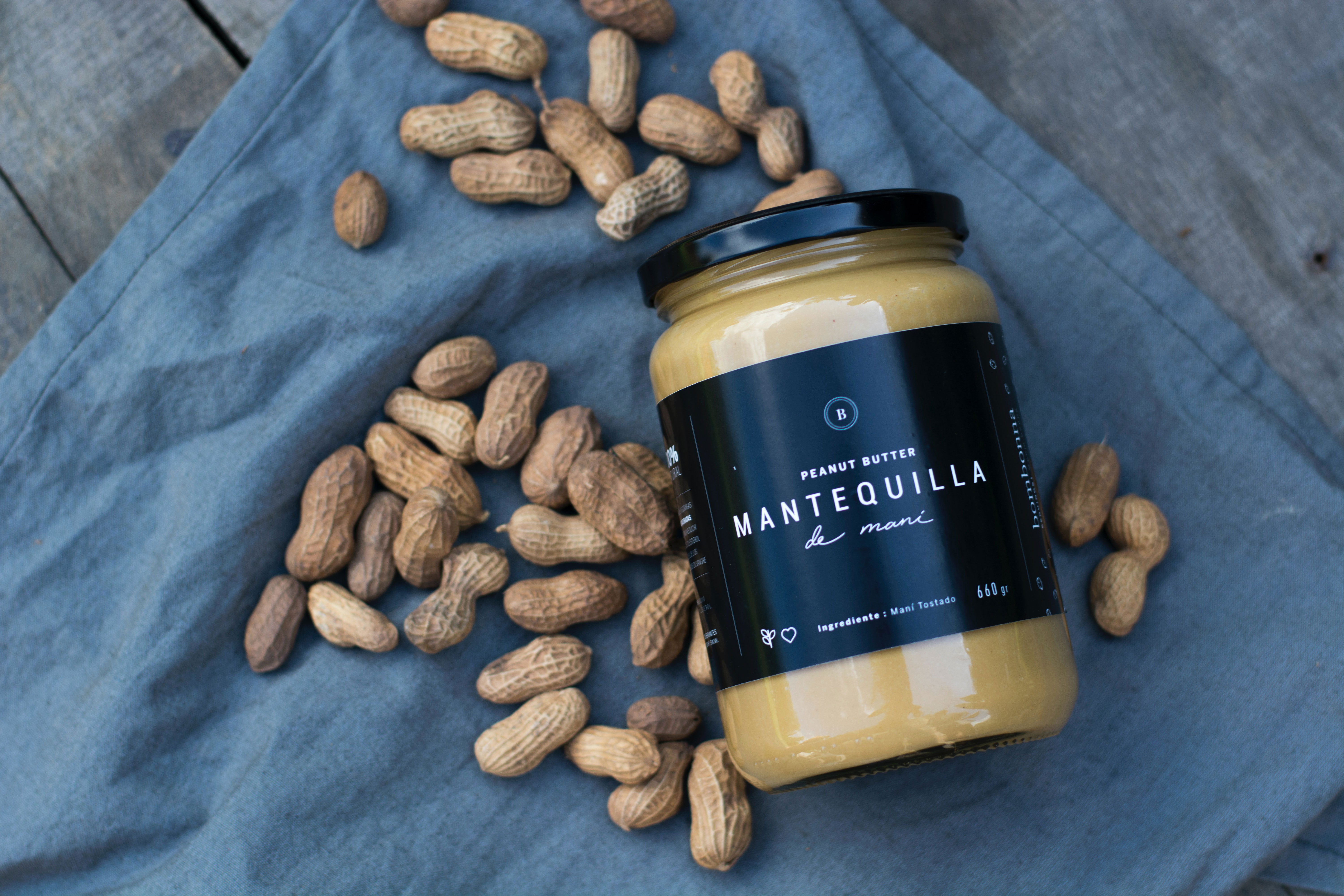 Peanut butter jar and peanuts on cloth; exploring food safety for dogs.