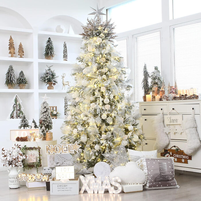 Large Christmas tree decorated with light-colored ornaments and affordable Christmas decor ideas for a festive holiday setting.