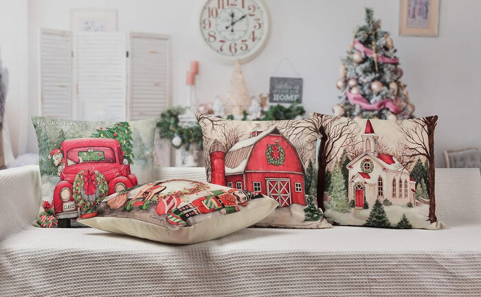 Sofa with affordable Christmas decor pillows featuring festive holiday scenes in a cozy living room setting for 2024.