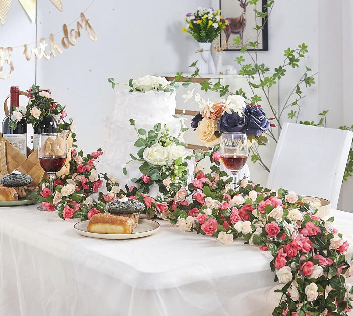 Floral garland centerpiece on dining table showcasing affordable Christmas decor ideas with pink and white flowers and greenery.