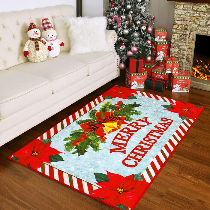 Christmas decor featuring a festive rug with poinsettias and gift boxes by a decorated tree and cozy fireplace.